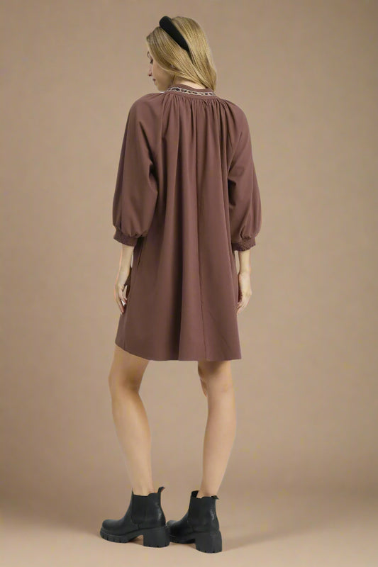 Woman wearing a brown dress on a white background