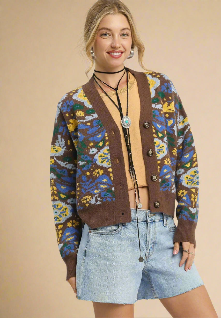 Woman wearing a patterned cardigan with a plain background