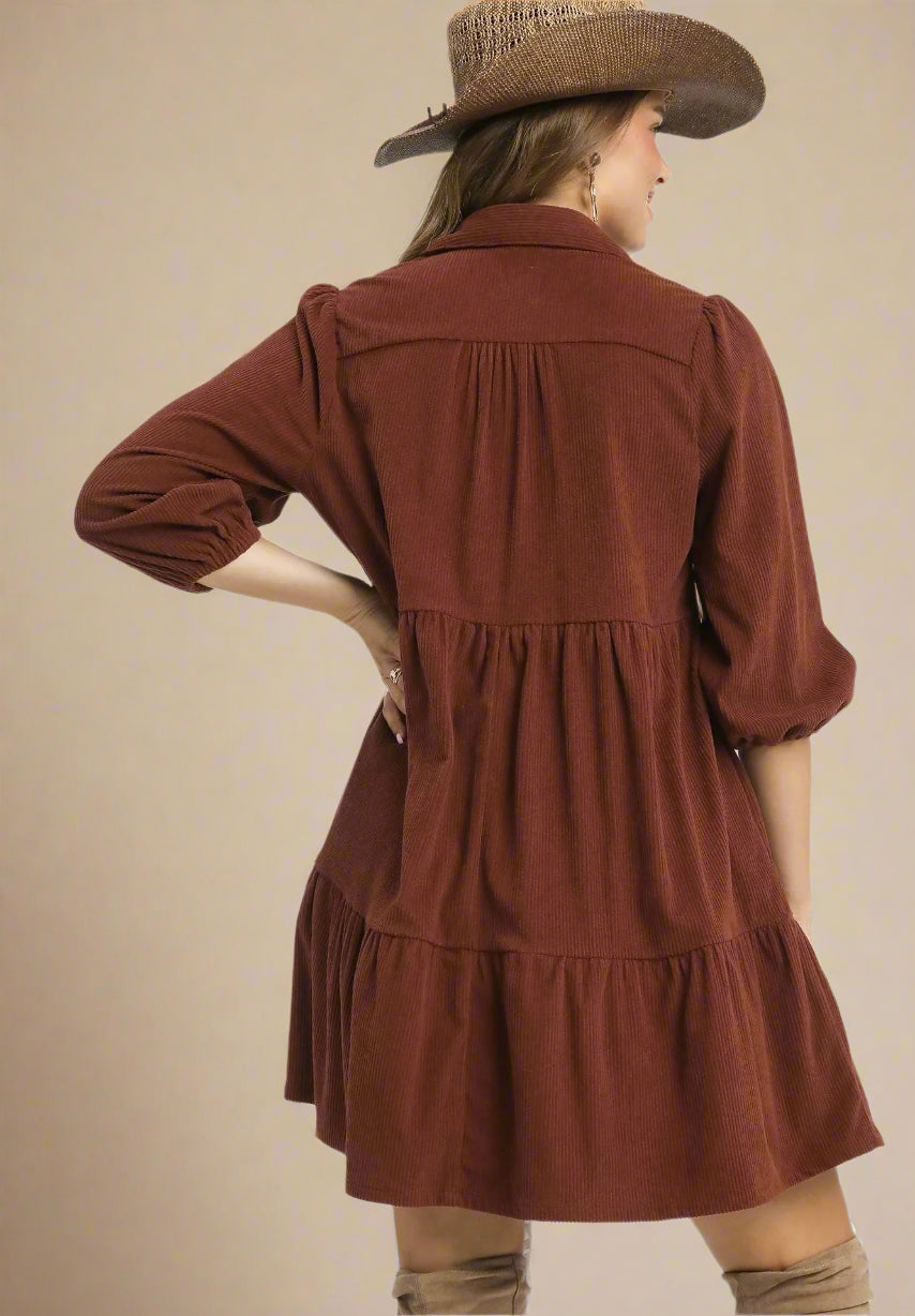 Woman wearing a brown dress with a hat on a beige background