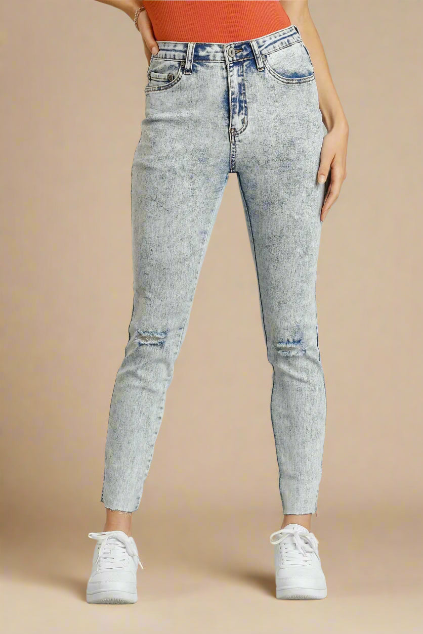 Light denim jeans worn by a person on a beige background