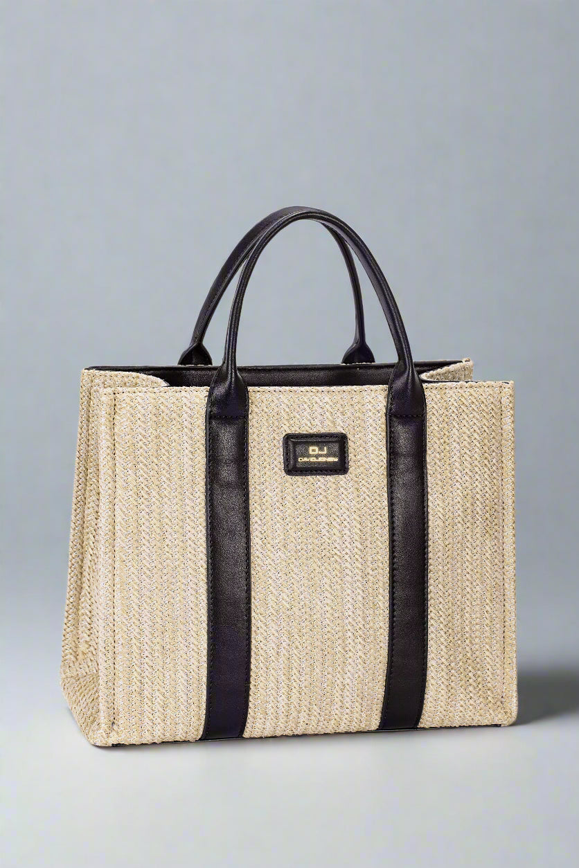 Beige straw tote bag with black handles and trim on a light gray background