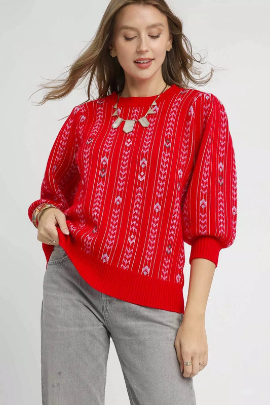 Woman wearing a red patterned sweater on a white background