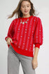 Woman wearing a red patterned sweater on a white background