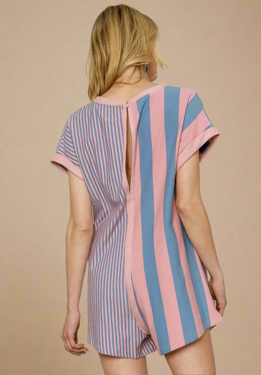 Woman wearing a striped romper with open back on a white background