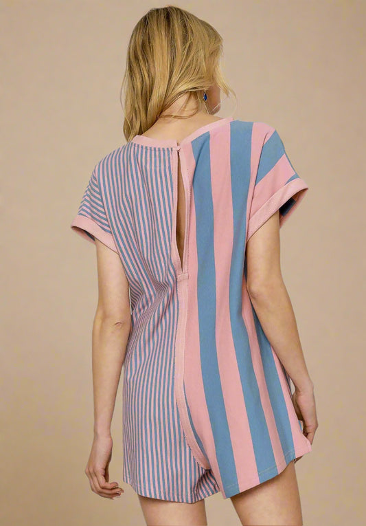 Woman wearing a striped romper with open back on a white background
