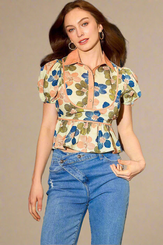 Woman wearing a floral blouse and blue jeans against a beige background
