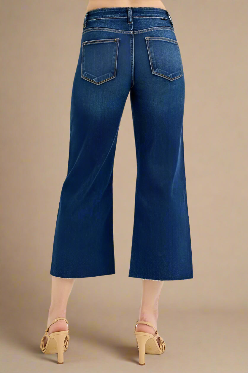 Blue jeans worn by a person on a beige background