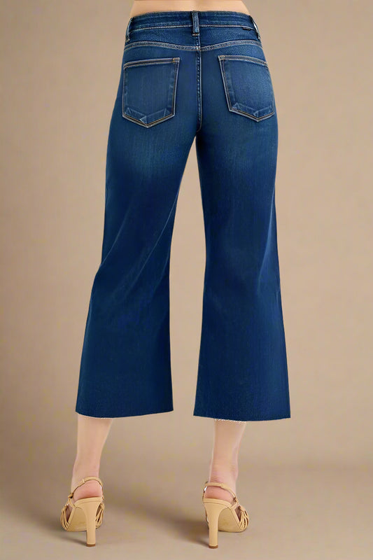 Blue jeans worn by a person on a beige background