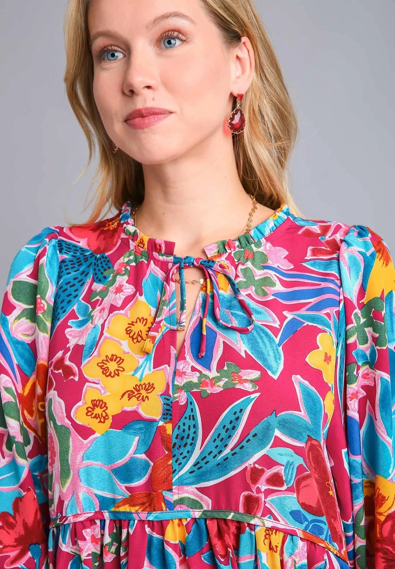 Woman wearing a colorful floral dress with a gray background