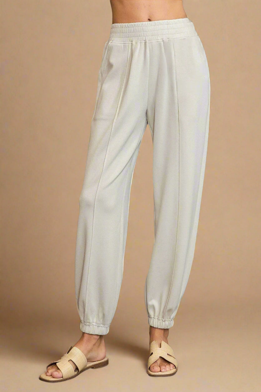Beige pants worn by a person on a gray background