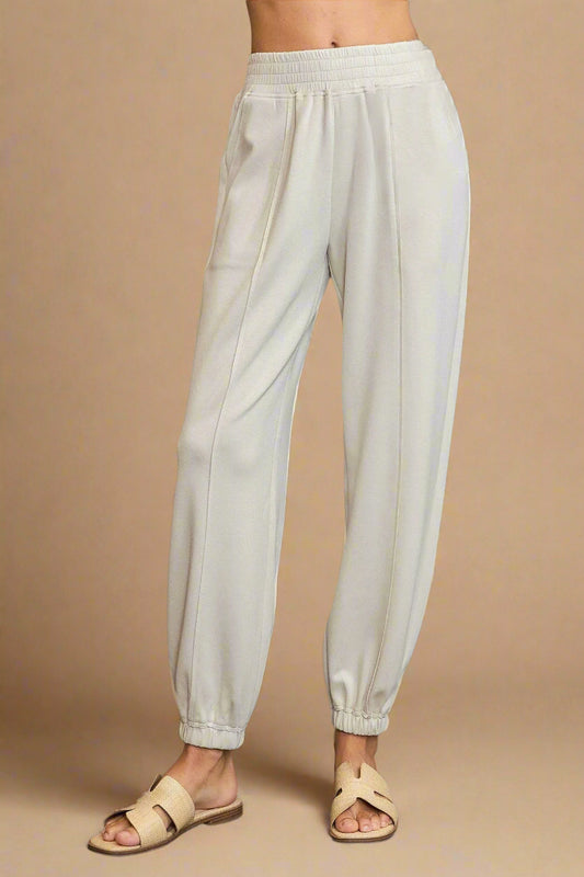 Beige pants worn by a person on a gray background