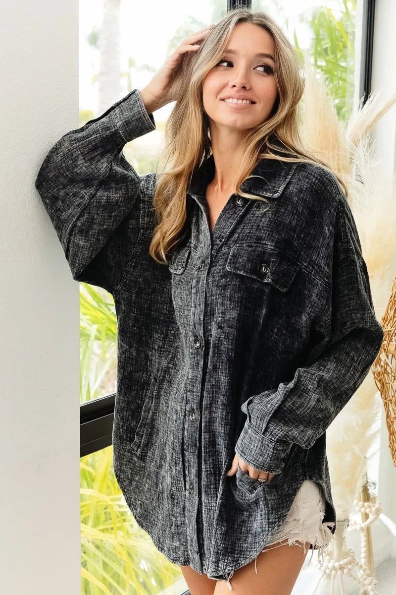 Woman wearing a gray oversized shirt with a blurred indoor background