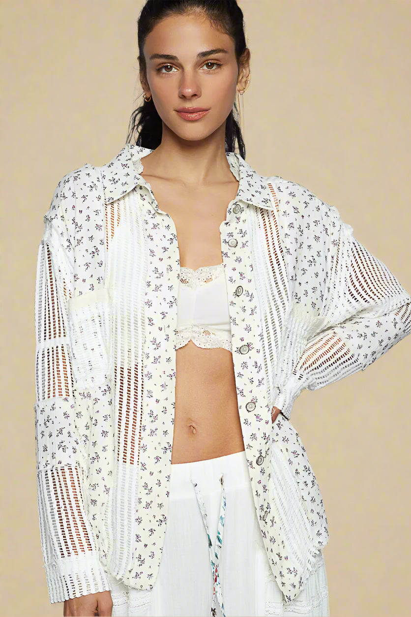 Woman wearing a white floral lace cover-up over a swimsuit on a beige background