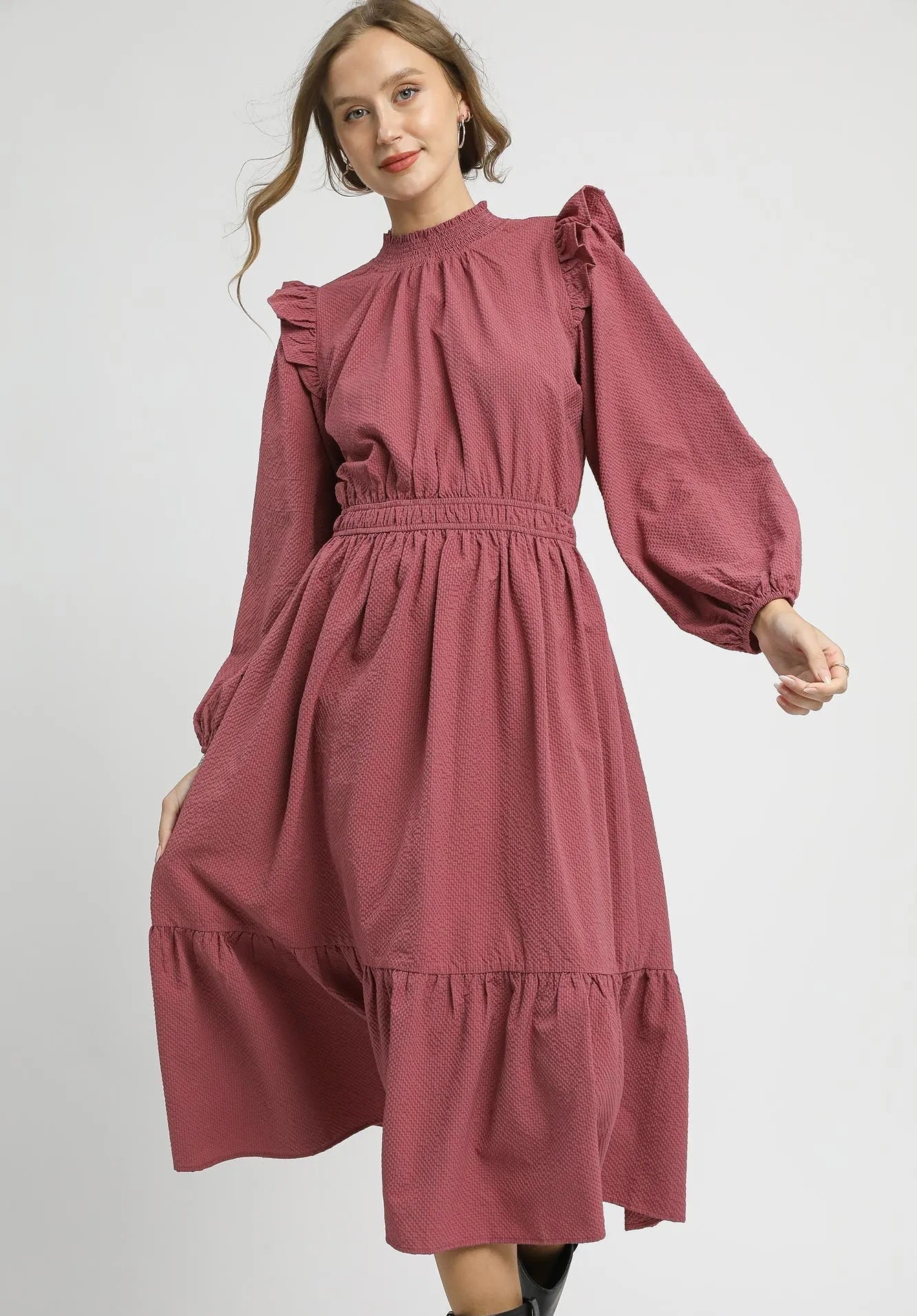 Woman wearing a dusty rose dress on a white background