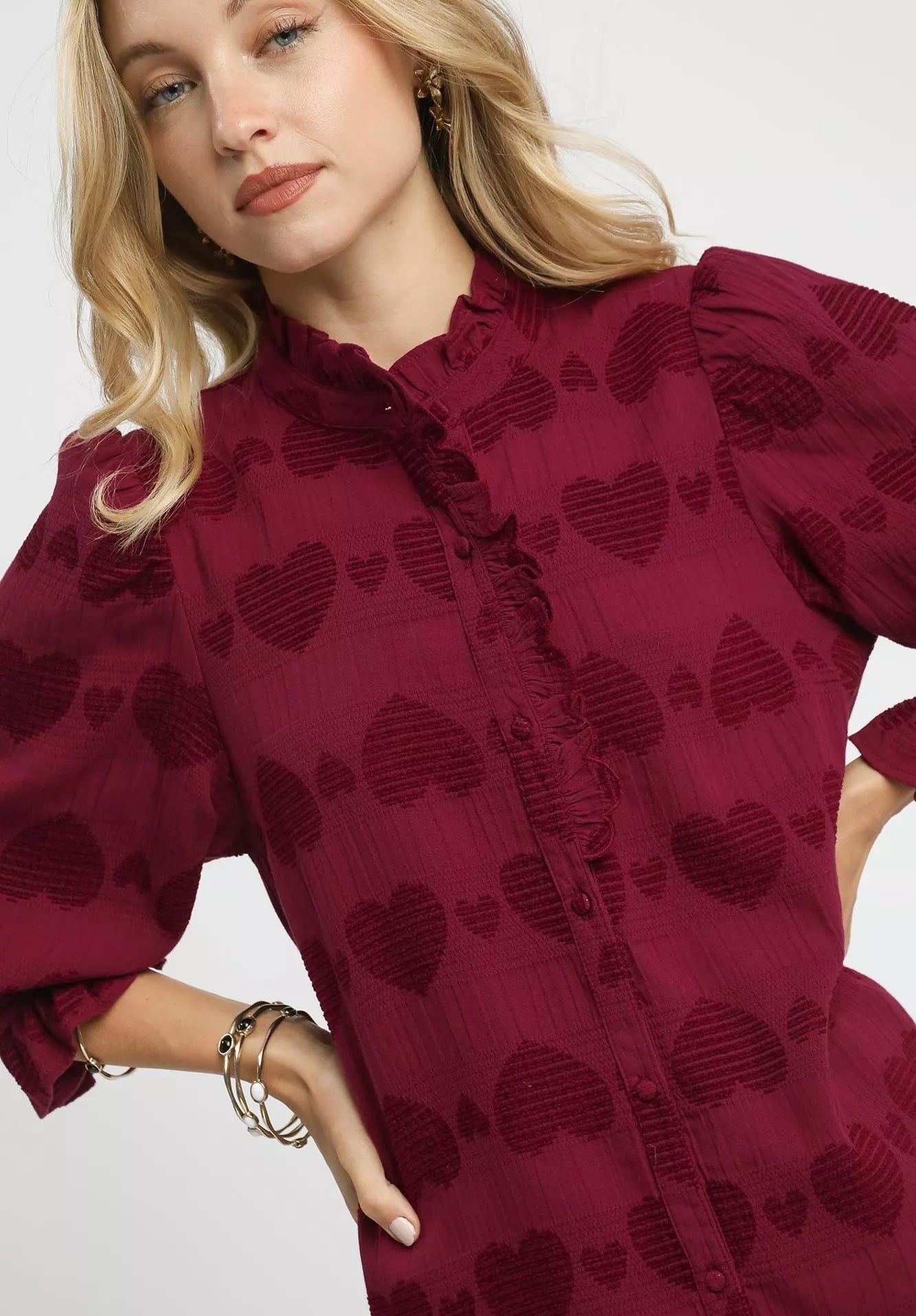 Woman wearing a red dress with heart patterns on a white background