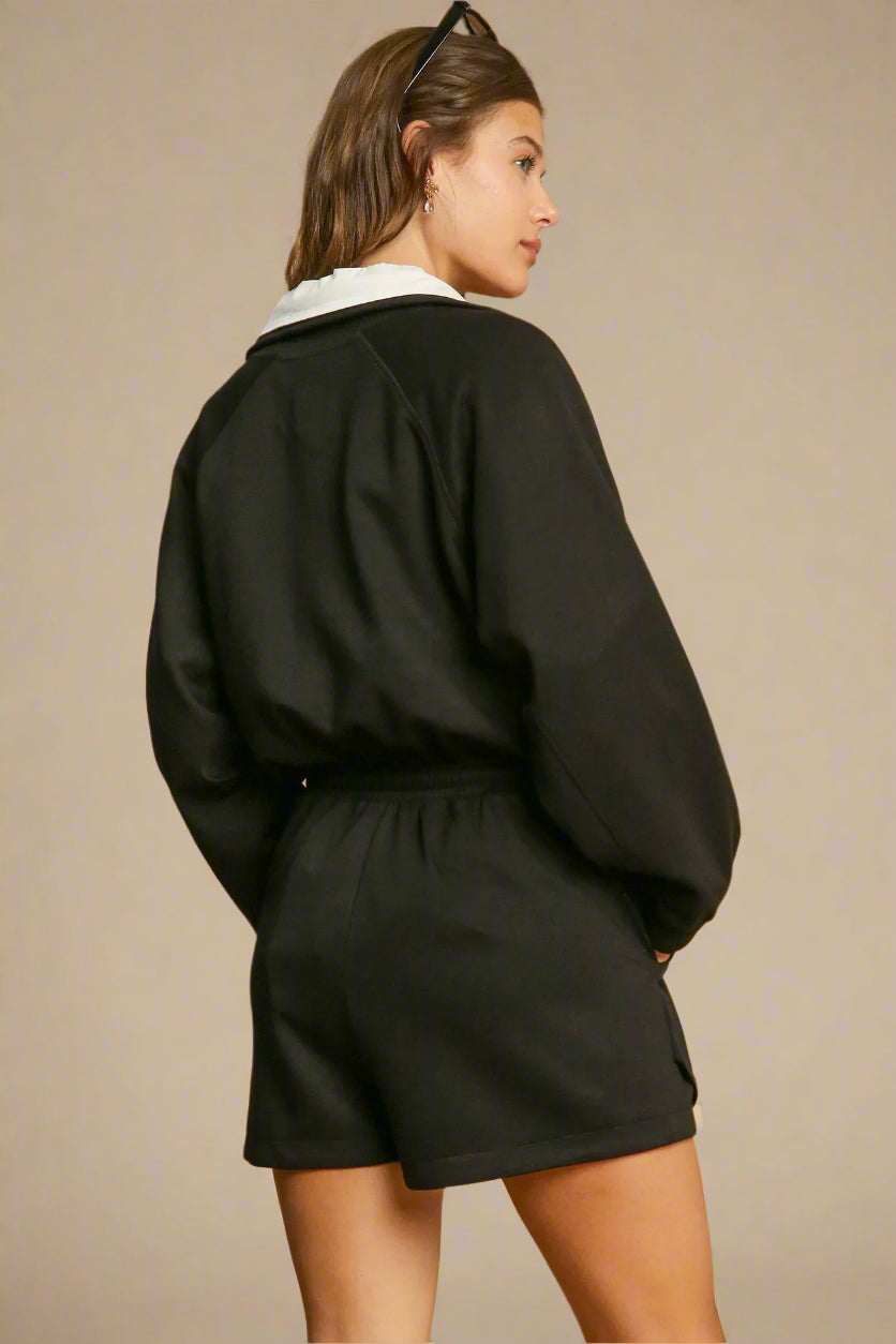 Woman wearing a black outfit on a beige background