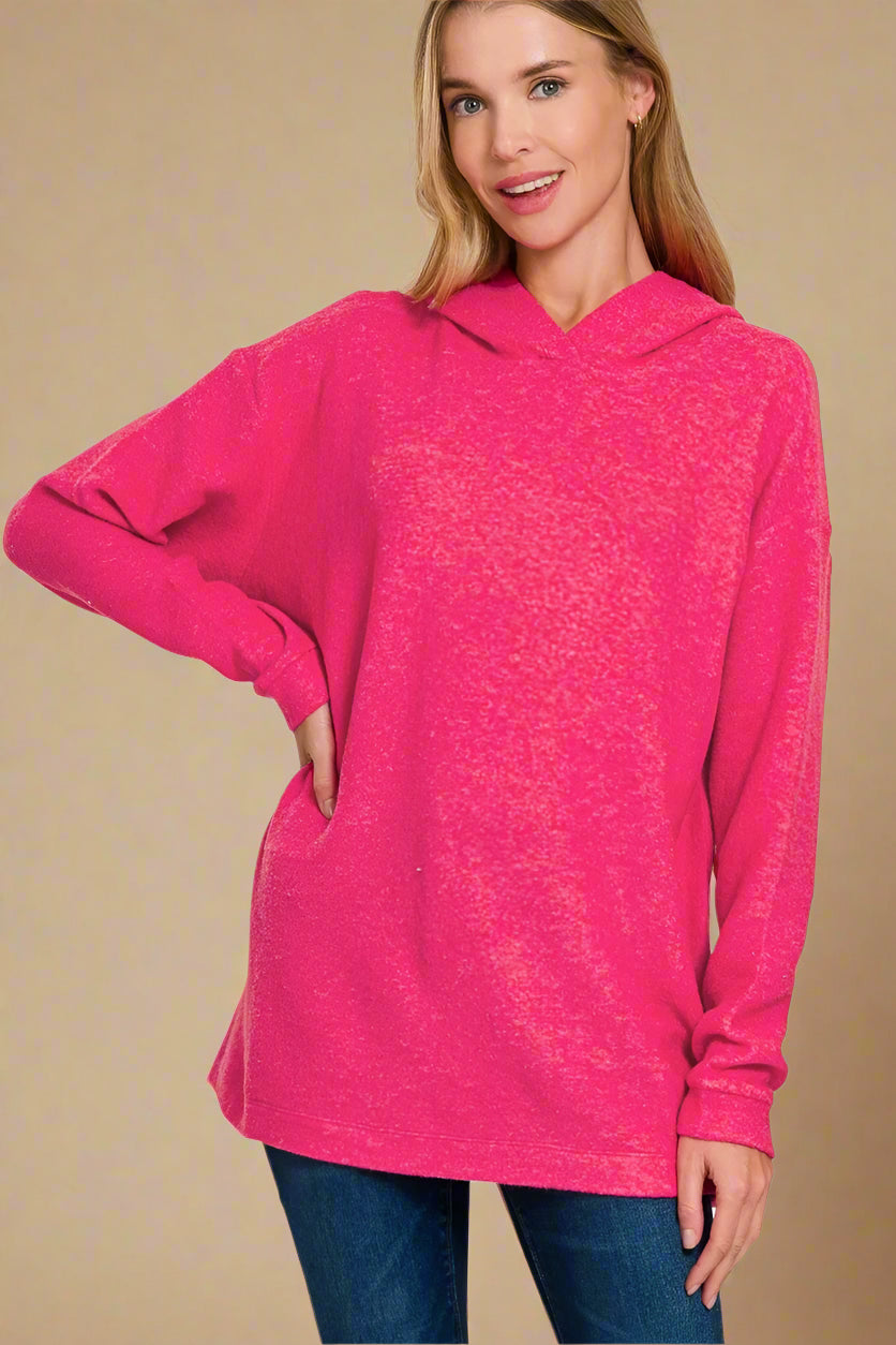 Woman wearing a hot pink hoodie on a beige background