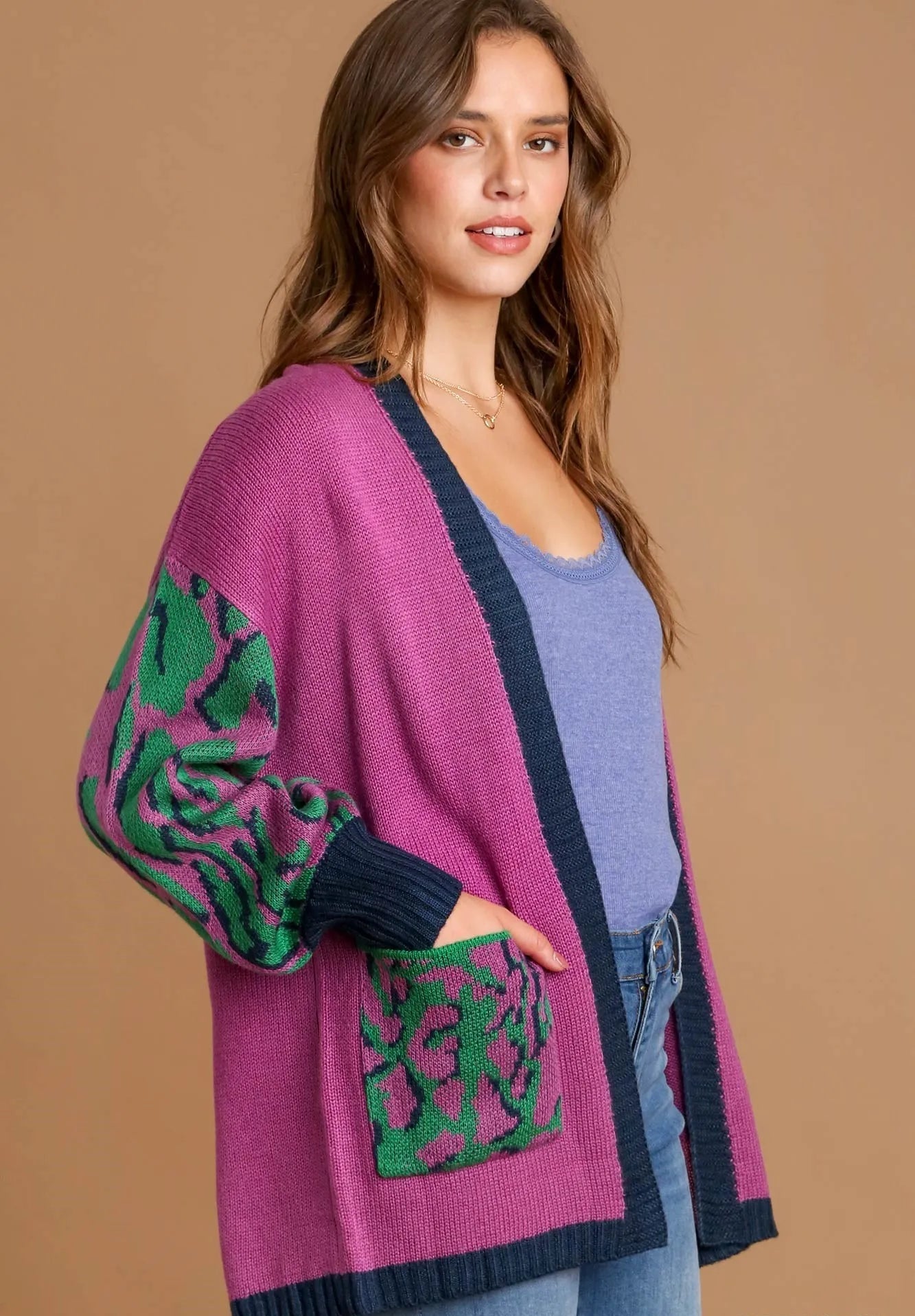 Woman wearing a purple cardigan with green patterns on a beige background