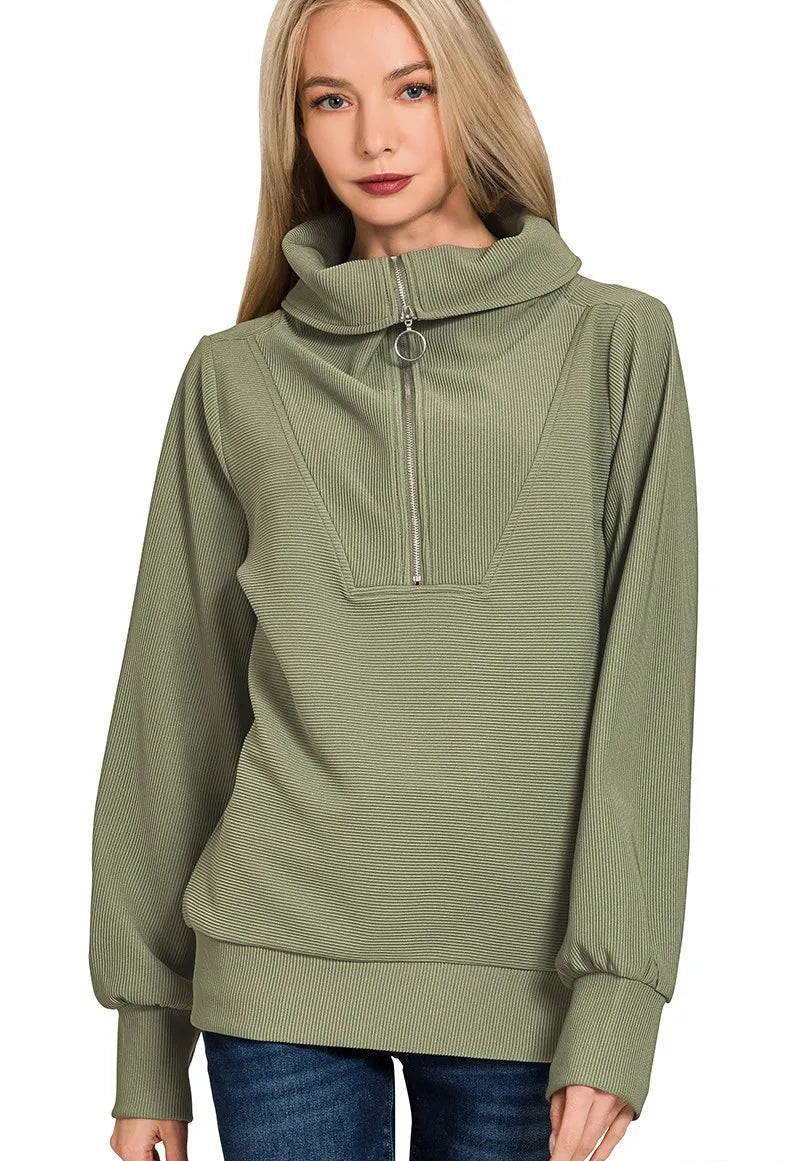 Woman wearing a light olive green pullover with a zipper on a white background