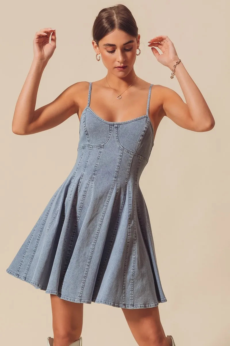 Woman wearing a denim dress against a beige background