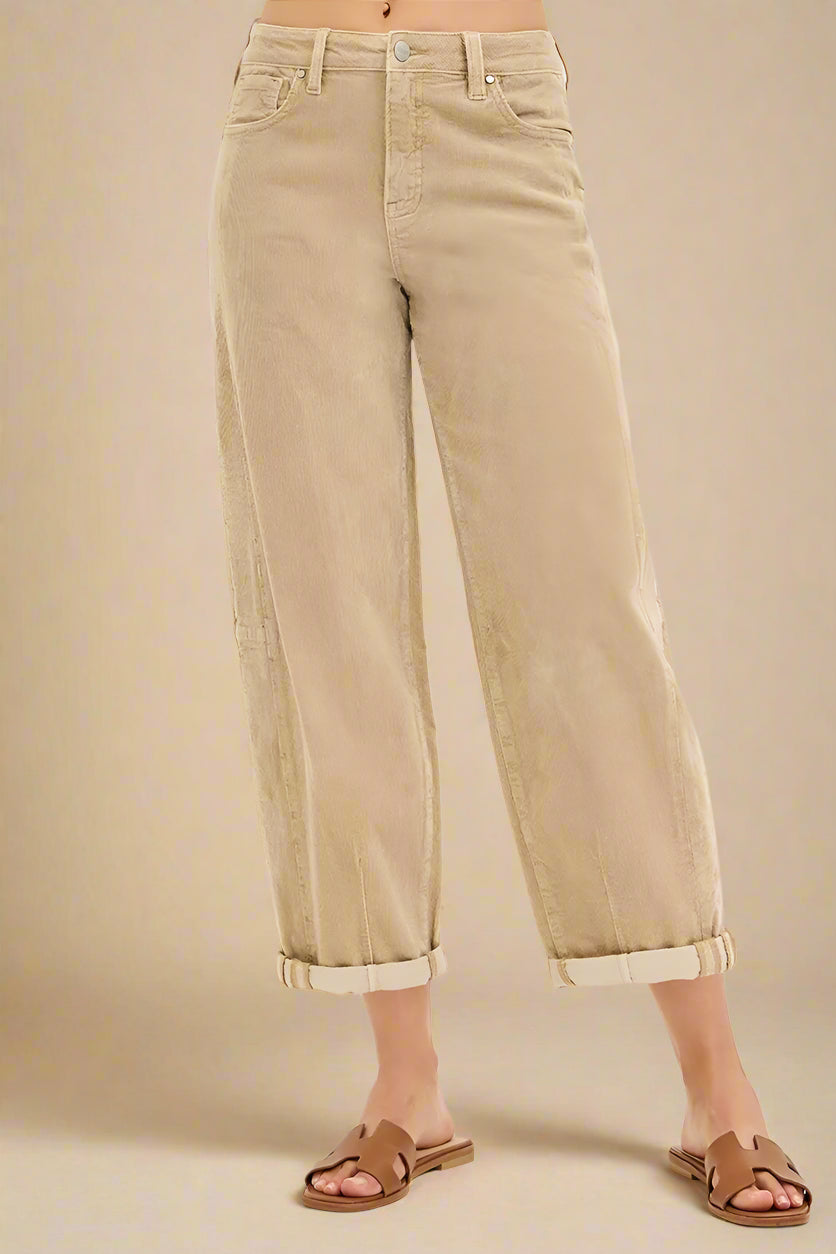 Beige wide-leg jeans worn by a person on a white background