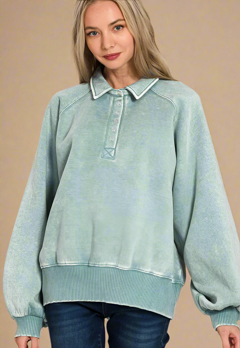 Woman wearing a light blue denim-style sweatshirt with a collar on a beige background