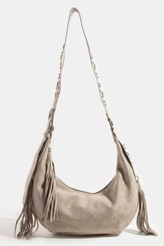 Beige handbag with fringe details on a white background