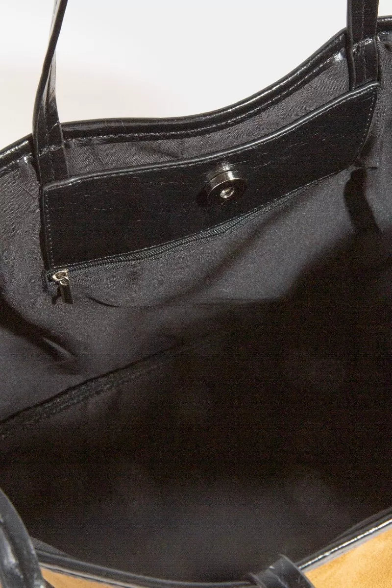 Close-up of a black handbag with a zipper detail.