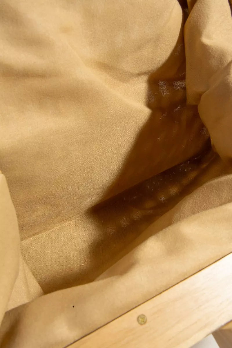 Close-up of beige fabric with a wooden surface underneath
