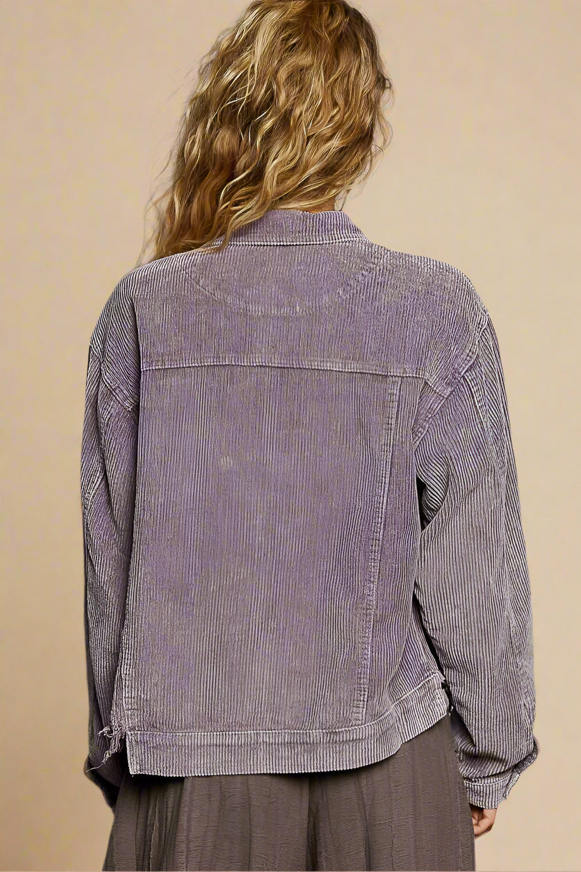 Person wearing a corduroy jacket with a plain background