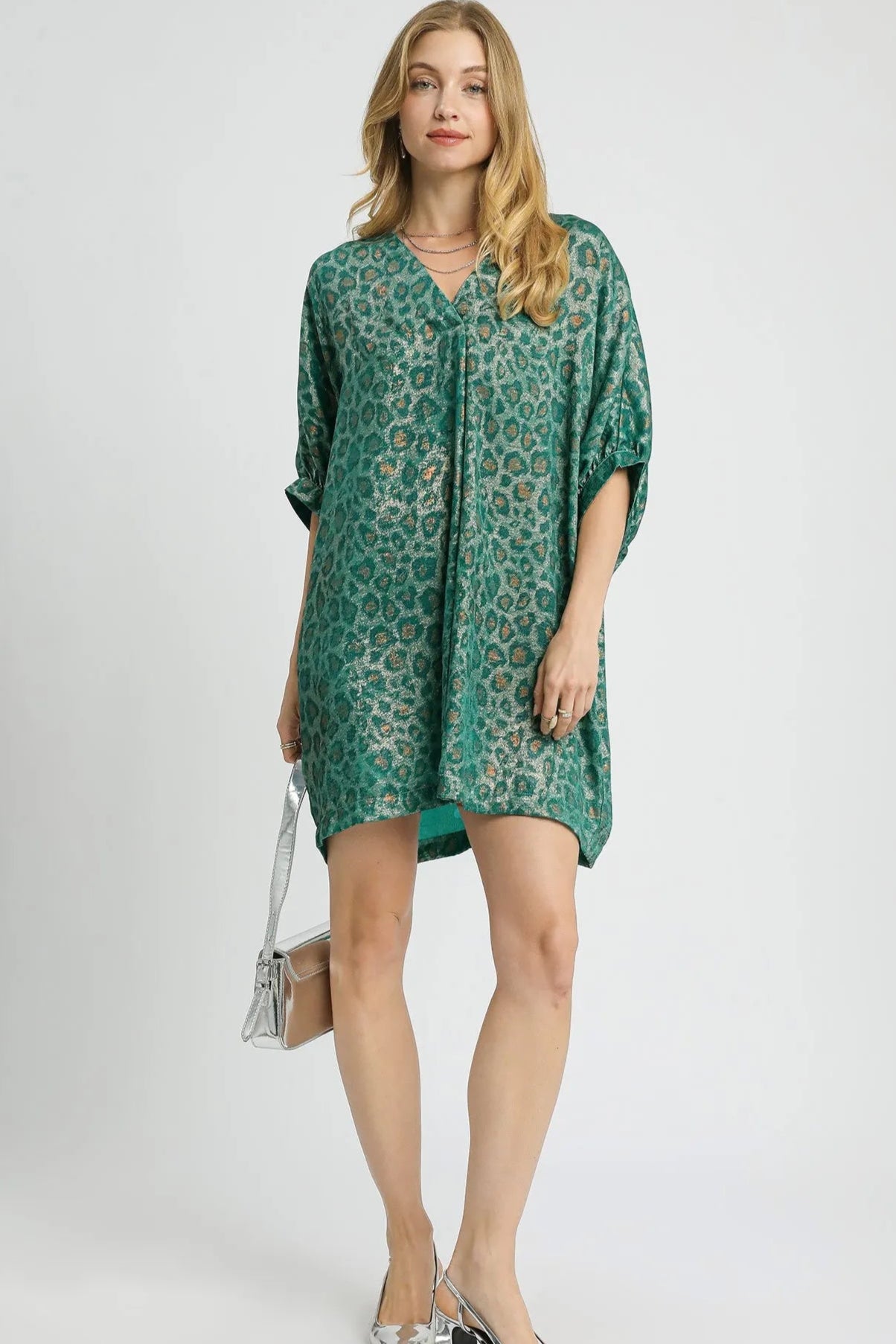 Woman wearing a green patterned dress on a white background