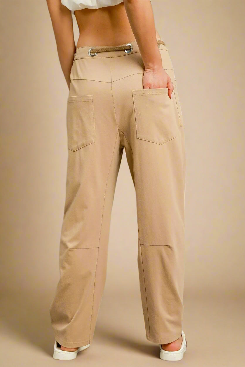 Beige pants worn by a person on a gray background