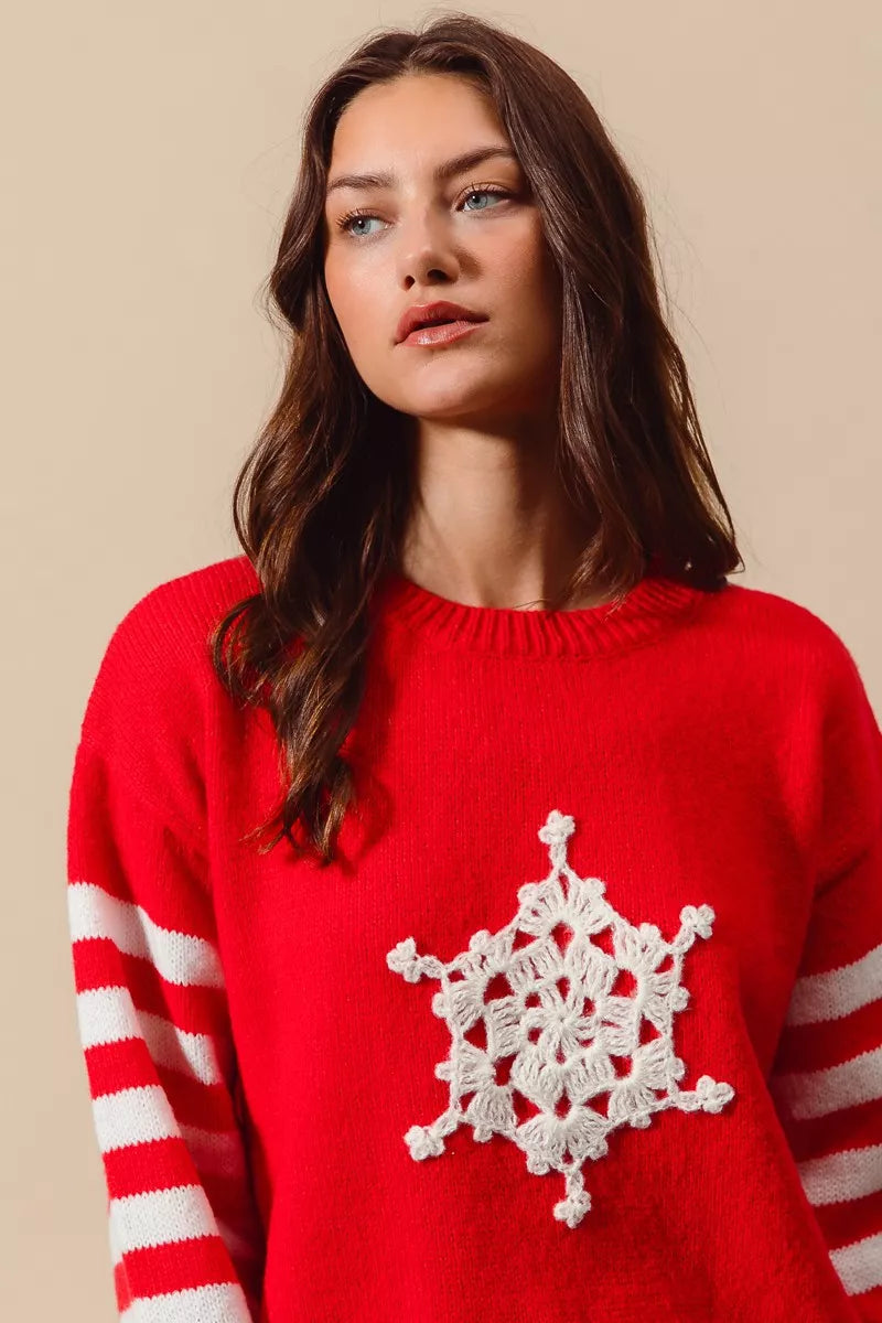 Woman wearing a red sweater with a white snowflake design on a beige background