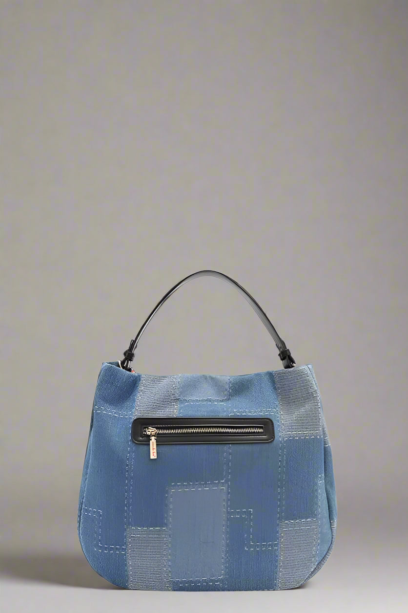 Blue patchwork handbag with a black zipper on a white background