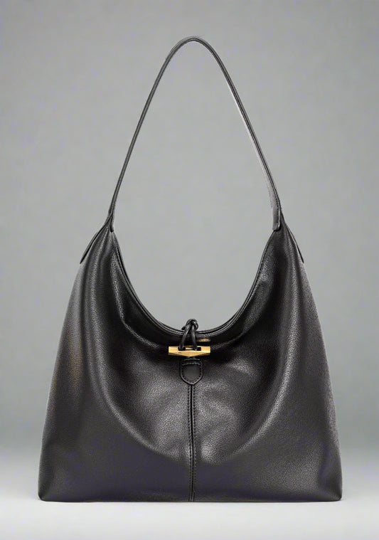 Black leather handbag with a gold clasp on a white background