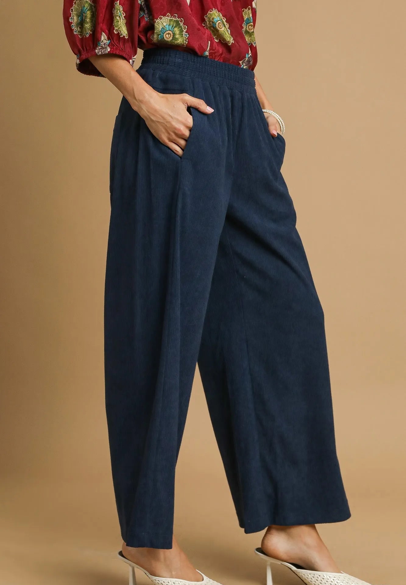 Navy blue pants worn by a person on a beige background