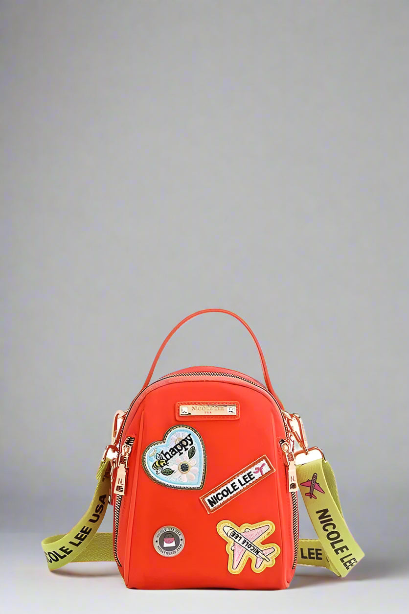 Red backpack with colorful patches and straps on a white background