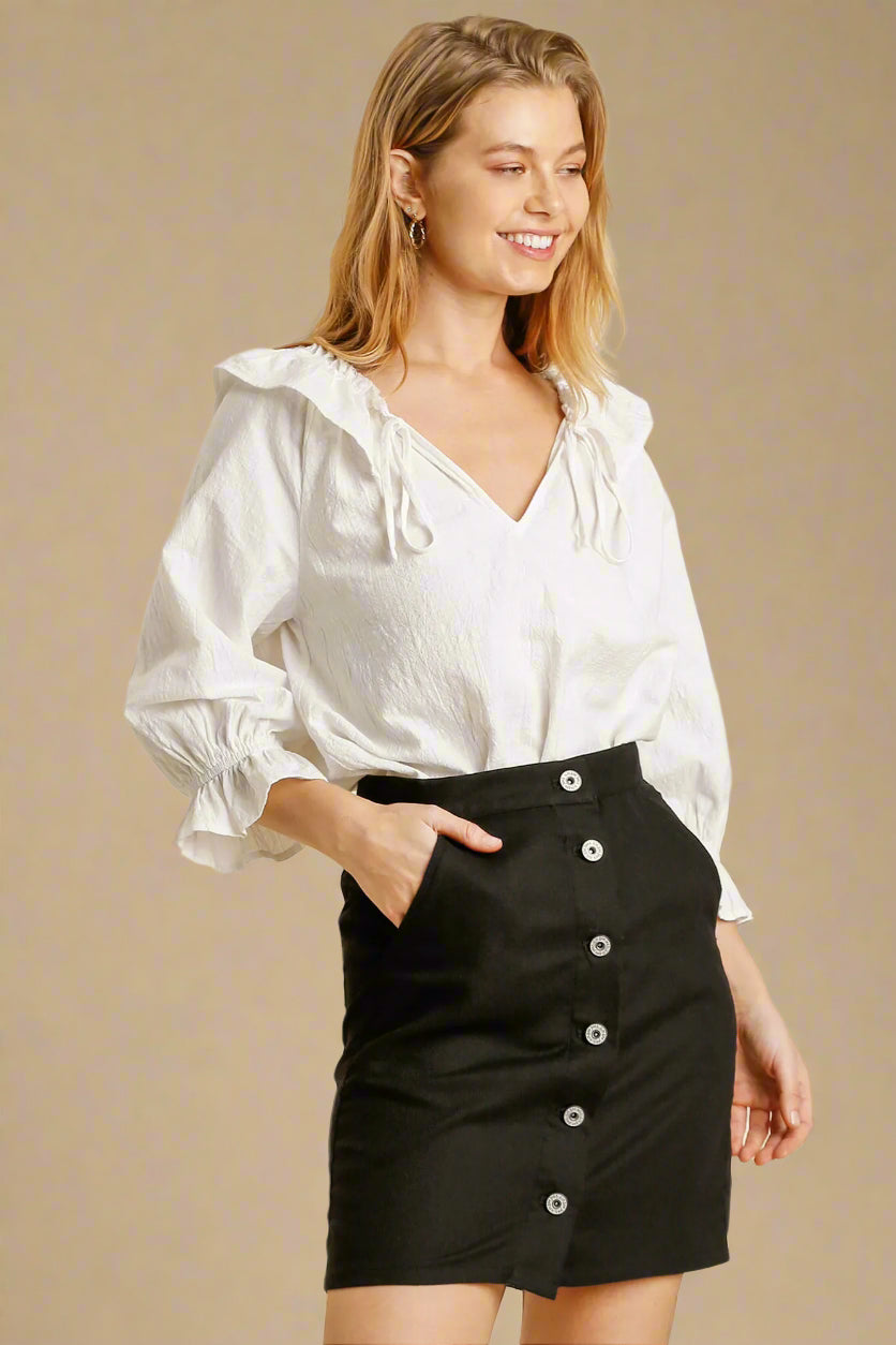 Woman wearing a white blouse and black skirt on a beige background