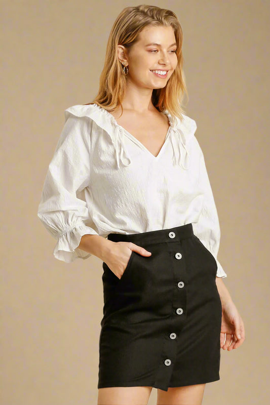 Woman wearing a white blouse and black skirt on a beige background