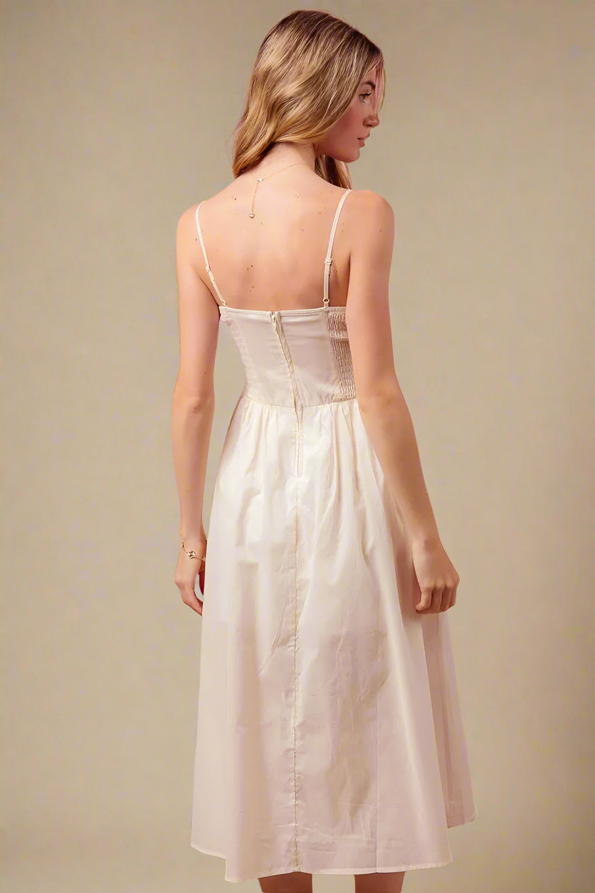 Woman wearing a white dress against a beige background