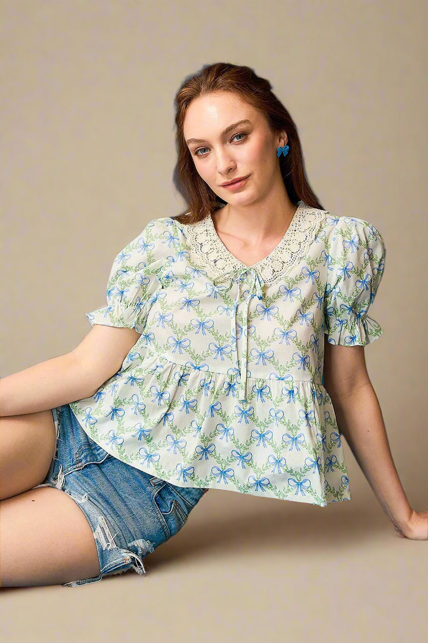 Woman wearing a floral blouse and denim shorts against a beige background