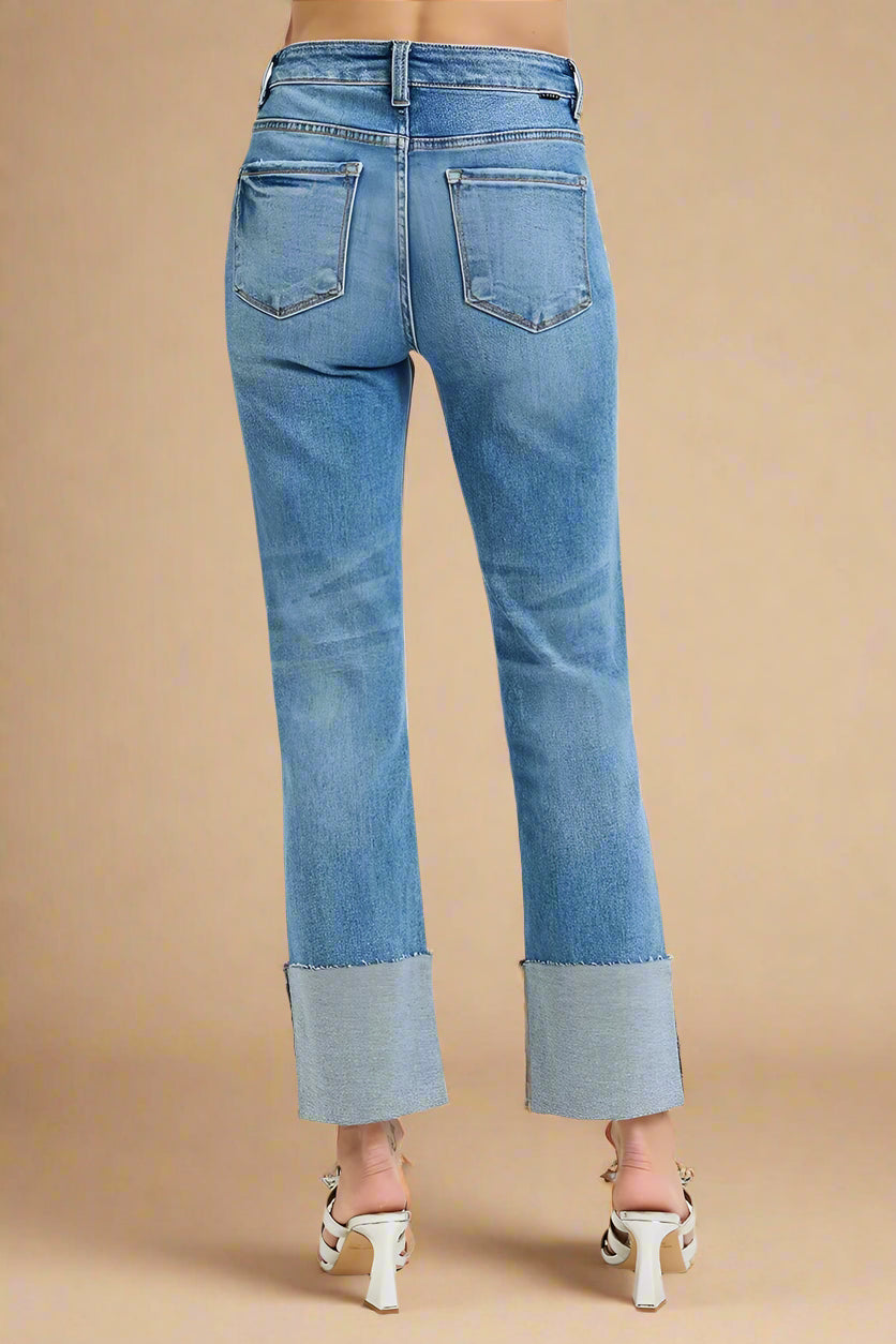 Blue jeans with cuffed hem on a white background