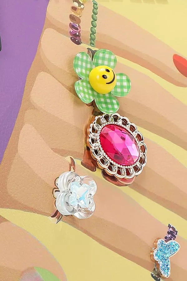 Colorful keychain with a smiley face design on a hand against a multicolored background