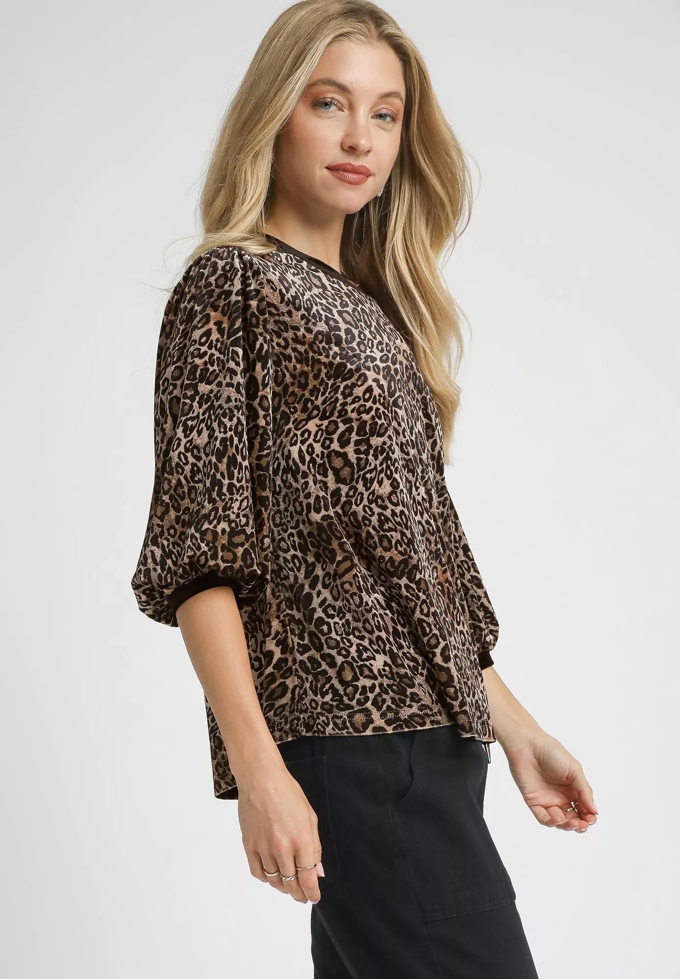Woman wearing a leopard print top on a white background