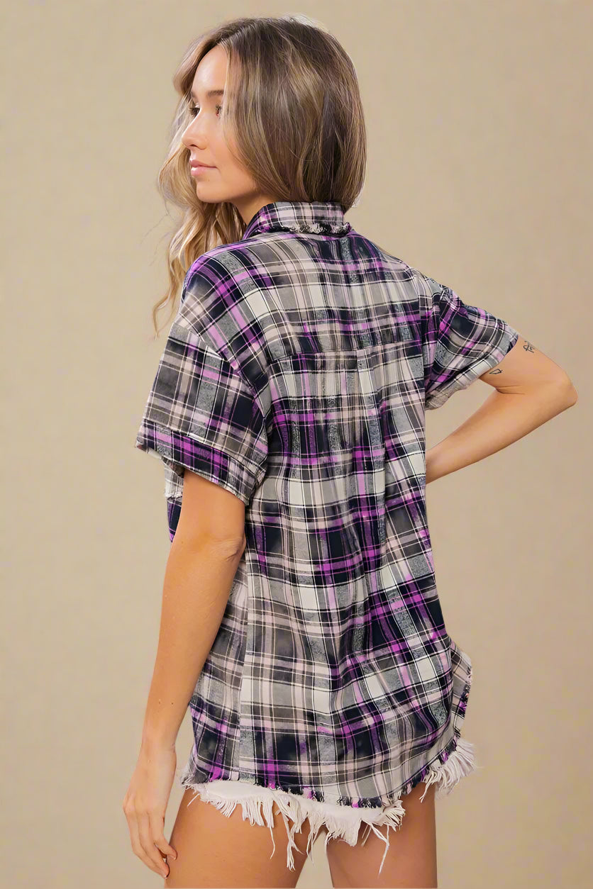 Woman wearing a plaid shirt and shorts in a home setting with decor elements.