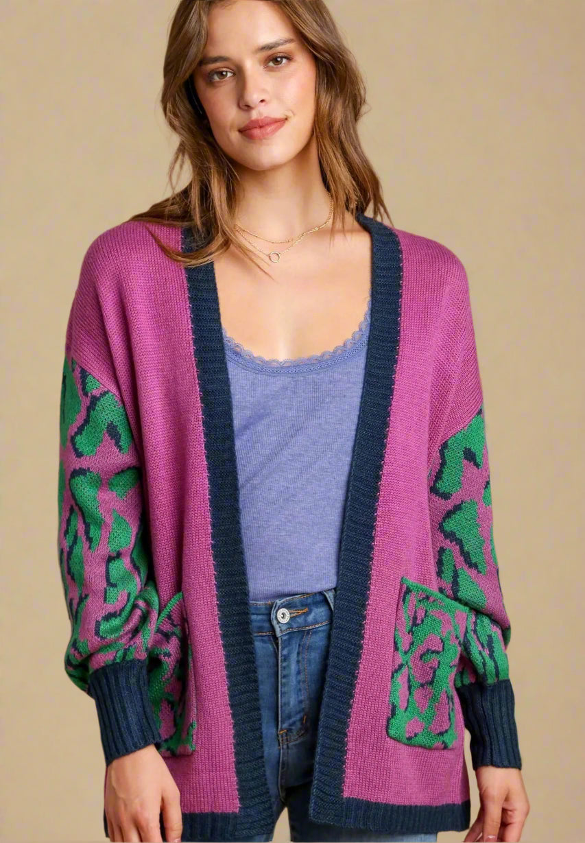 Woman wearing a pink cardigan with green patterns on a beige background