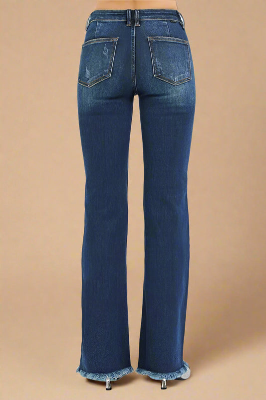 Blue jeans with frayed cuffs on a beige background