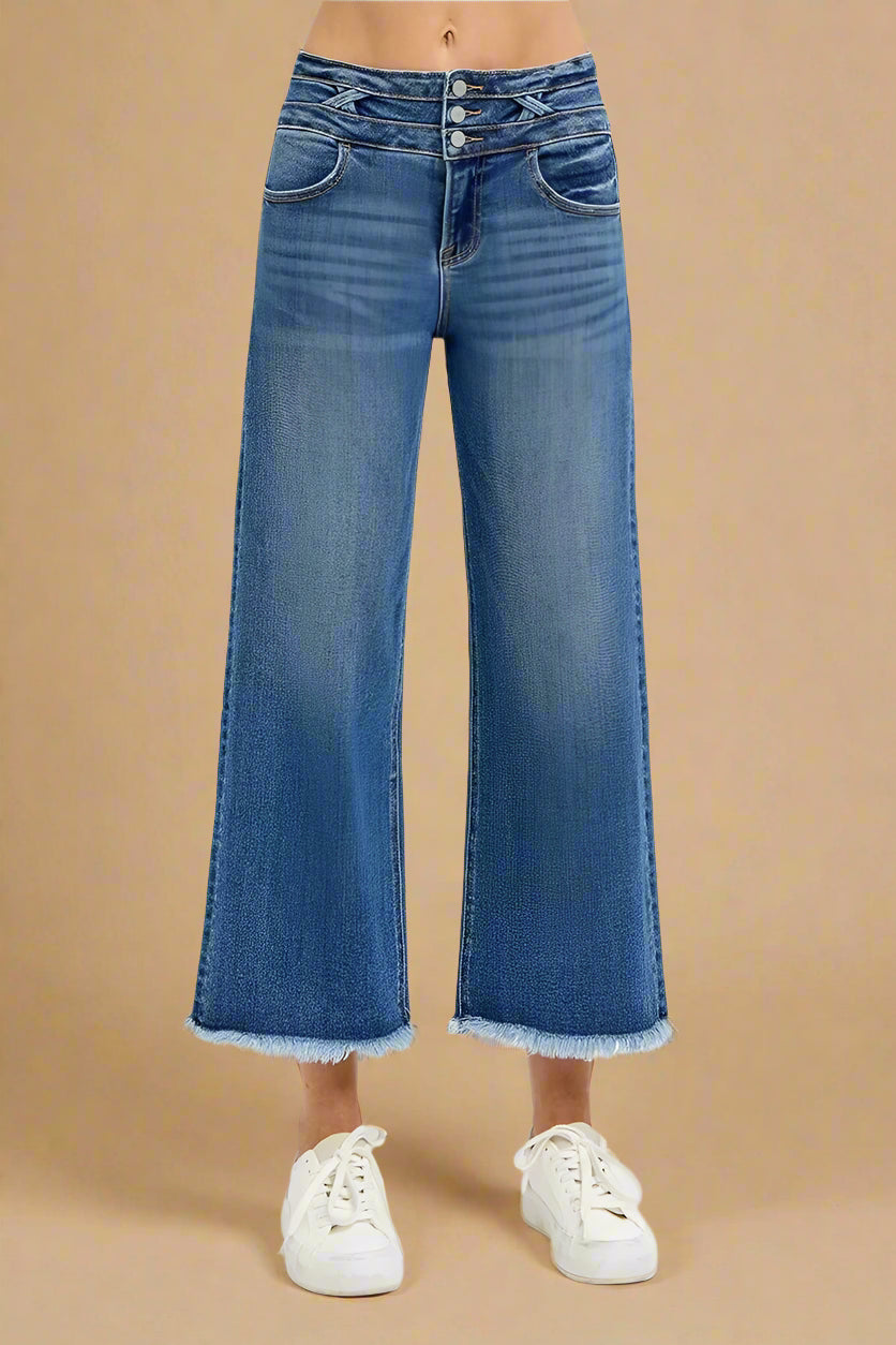 Blue jeans worn by a person on a beige background