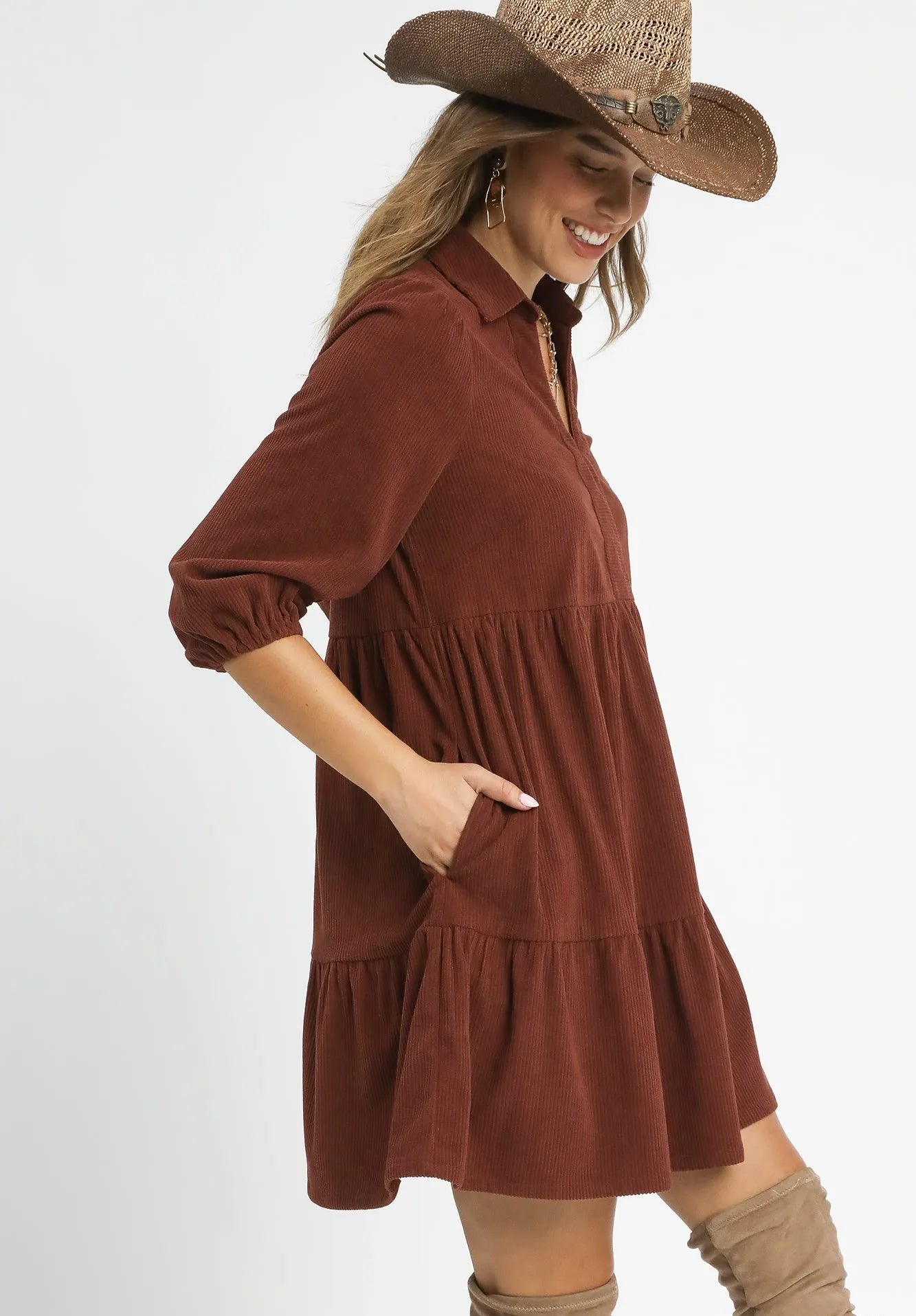 Woman wearing a red brown dress and cowboy hat on a white background