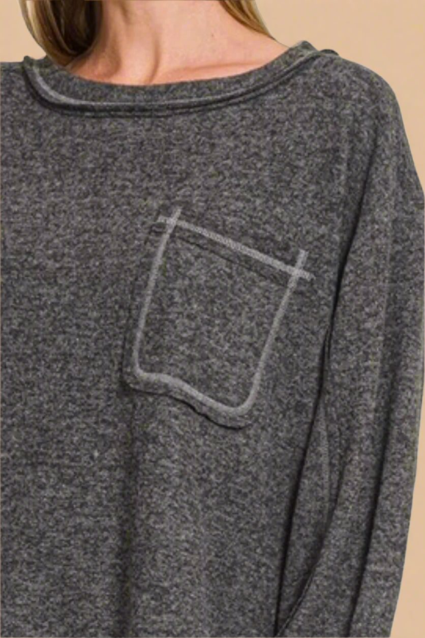 Gray long-sleeve shirt with a pocket detail on a plain background